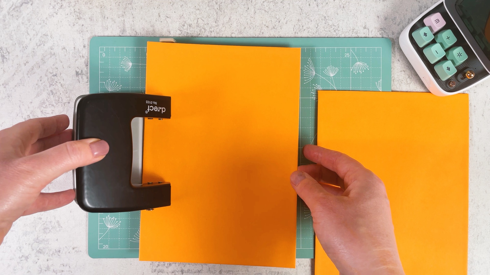 Punching holes along the edge of an orange cover