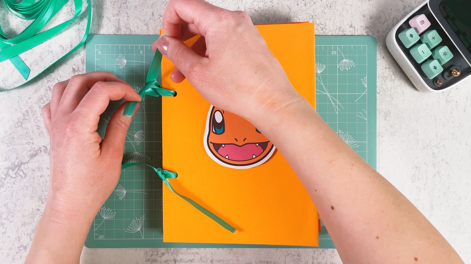 Tying the ribbon into a bow on the edge of the binder