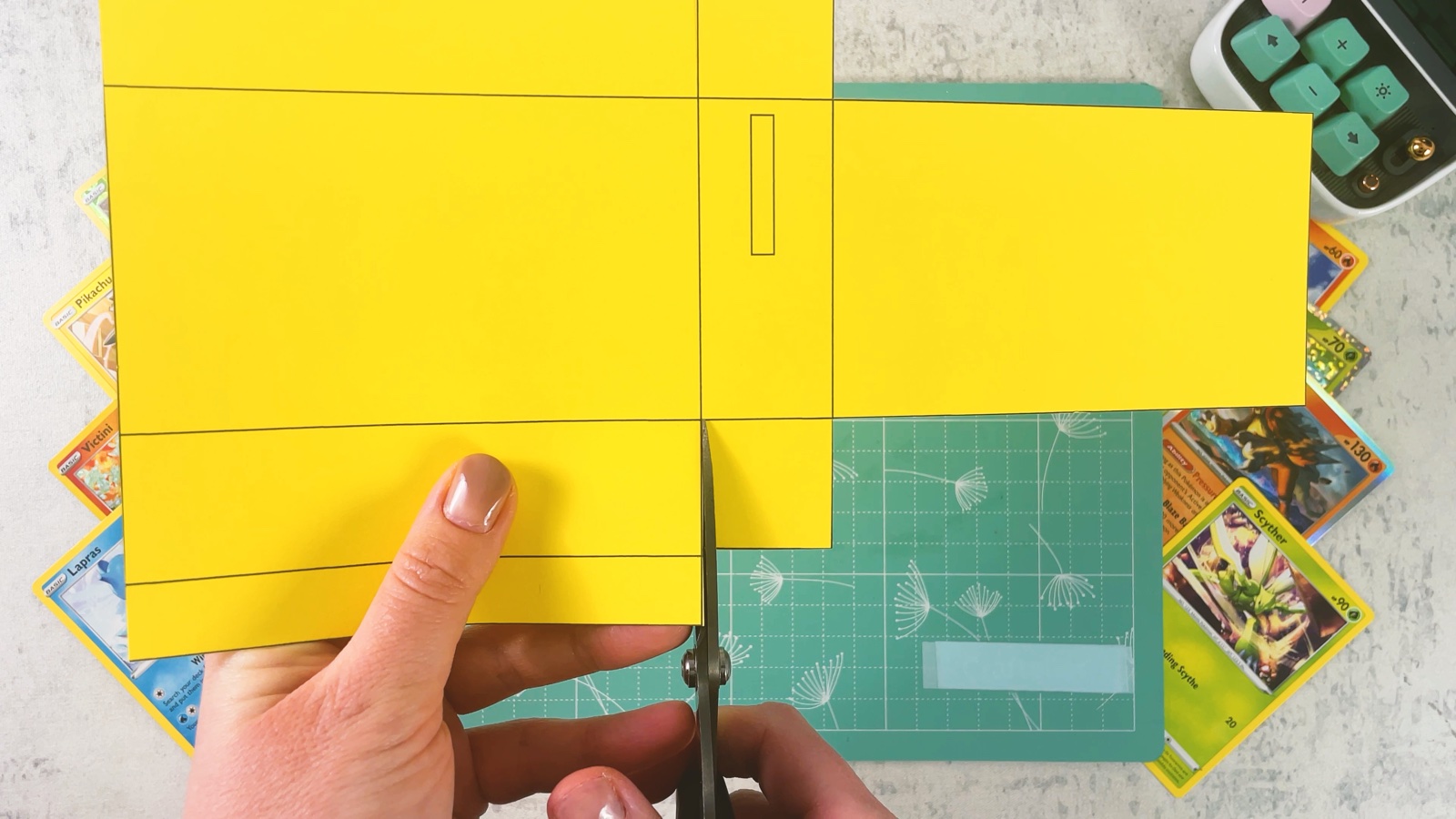 Cutting a short line between two flaps of the yellow base