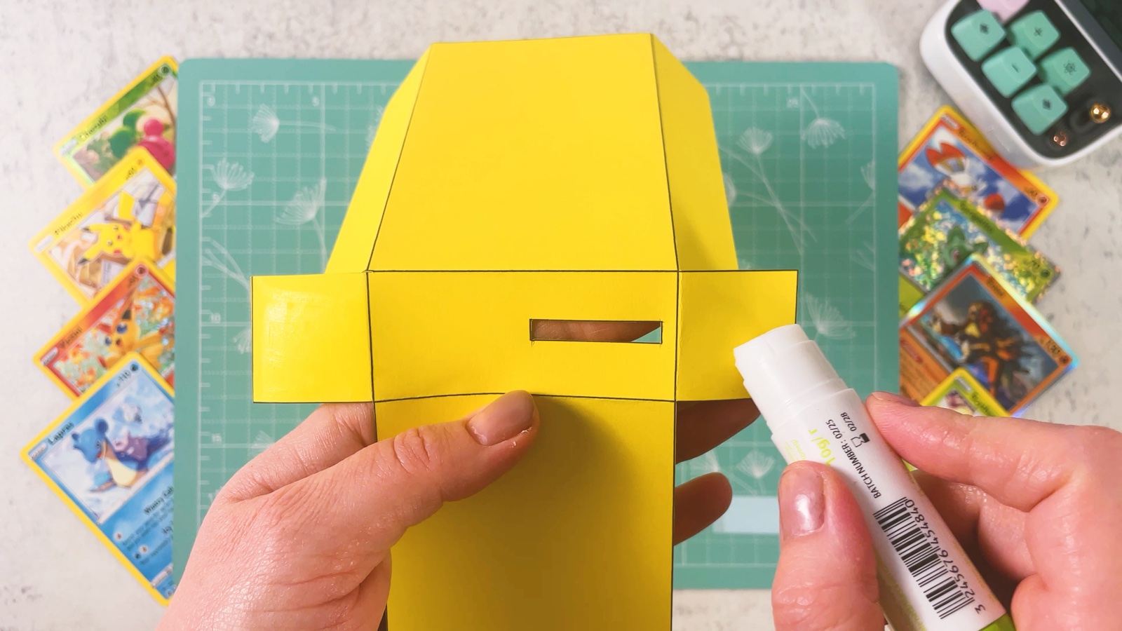 Gluing the flaps of the yellow base with a glue stick