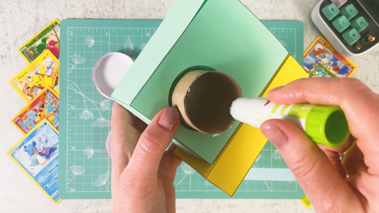 Putting glue on the end of the cardboard roll