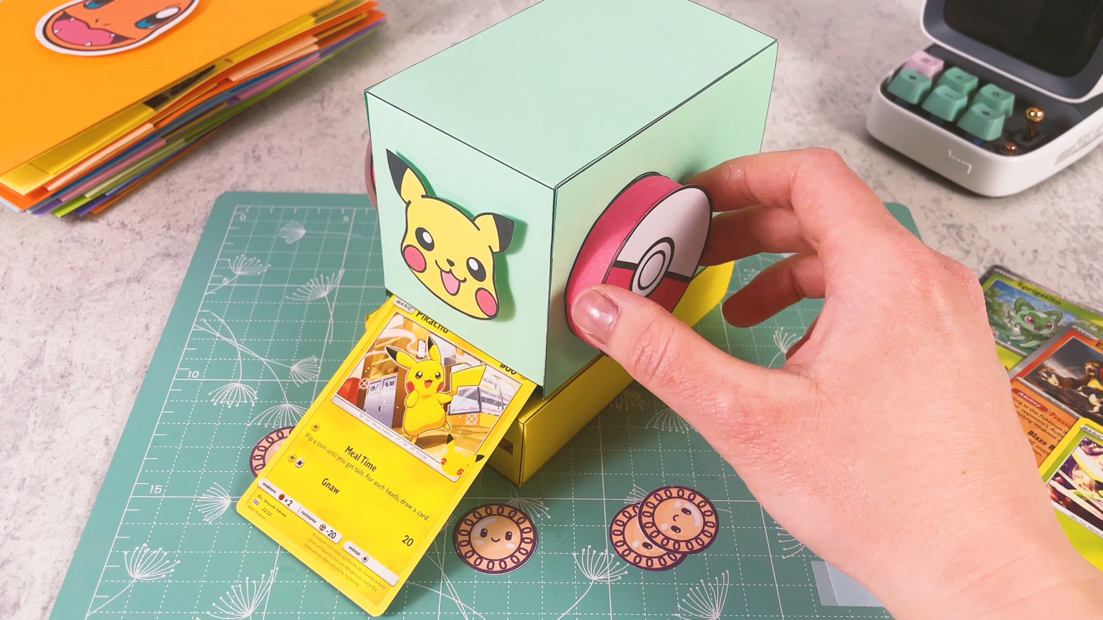 Turning the Poké Ball handle while a Pikachu card comes out of the front