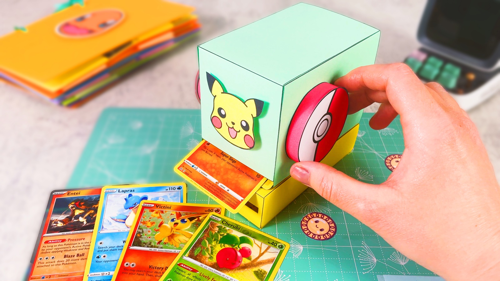Finished paper Pokémon card vending machine with a Pikachu face and a Poké Ball handle