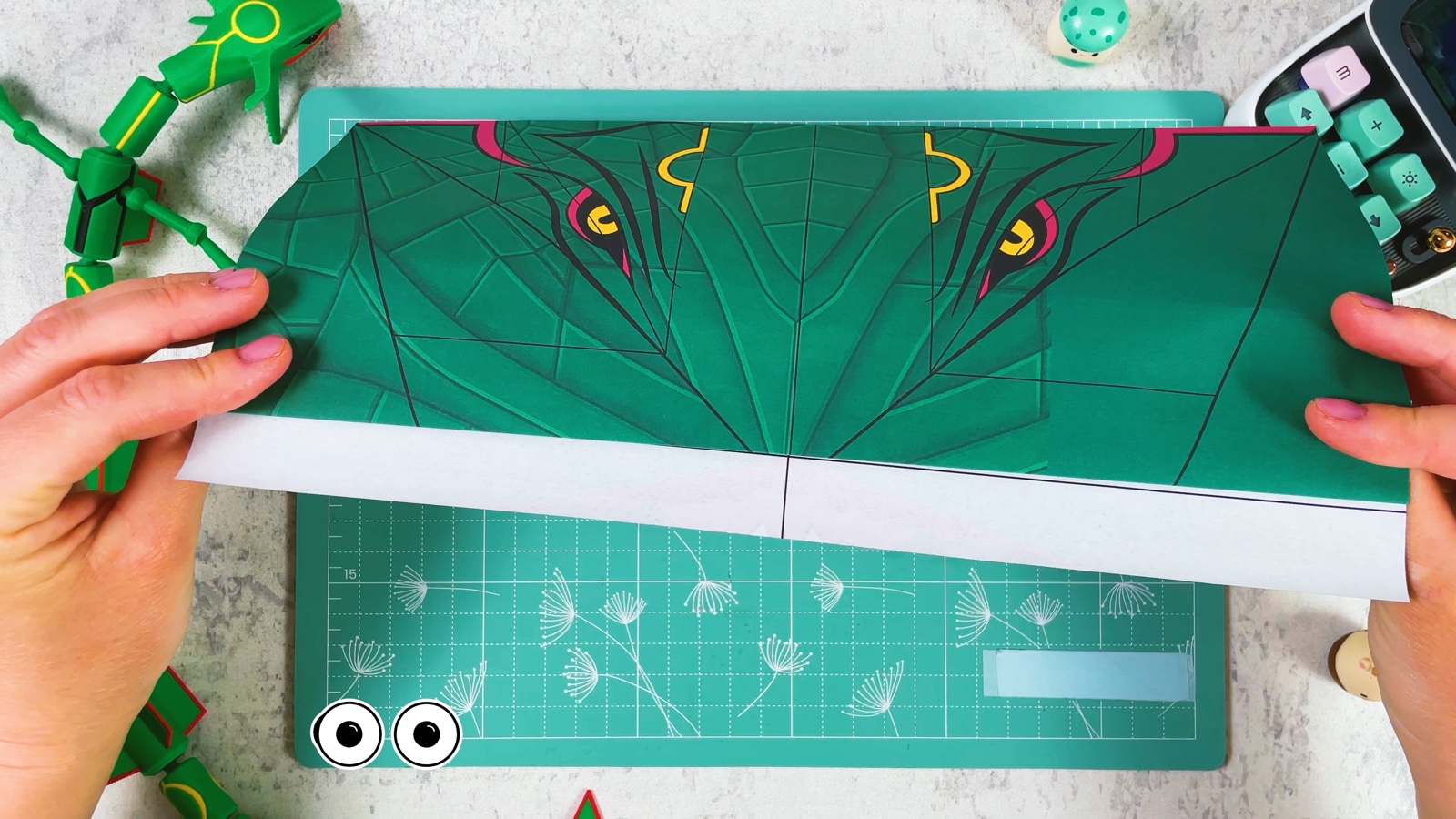 Turning the sheet over to show Rayquaza’s eyes, with the folded white strip along the bottom