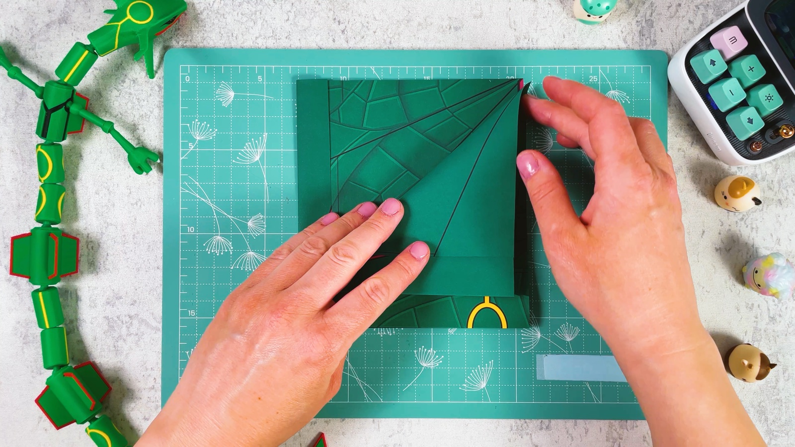 Folding the top corner of the green layer down along a printed diagonal line