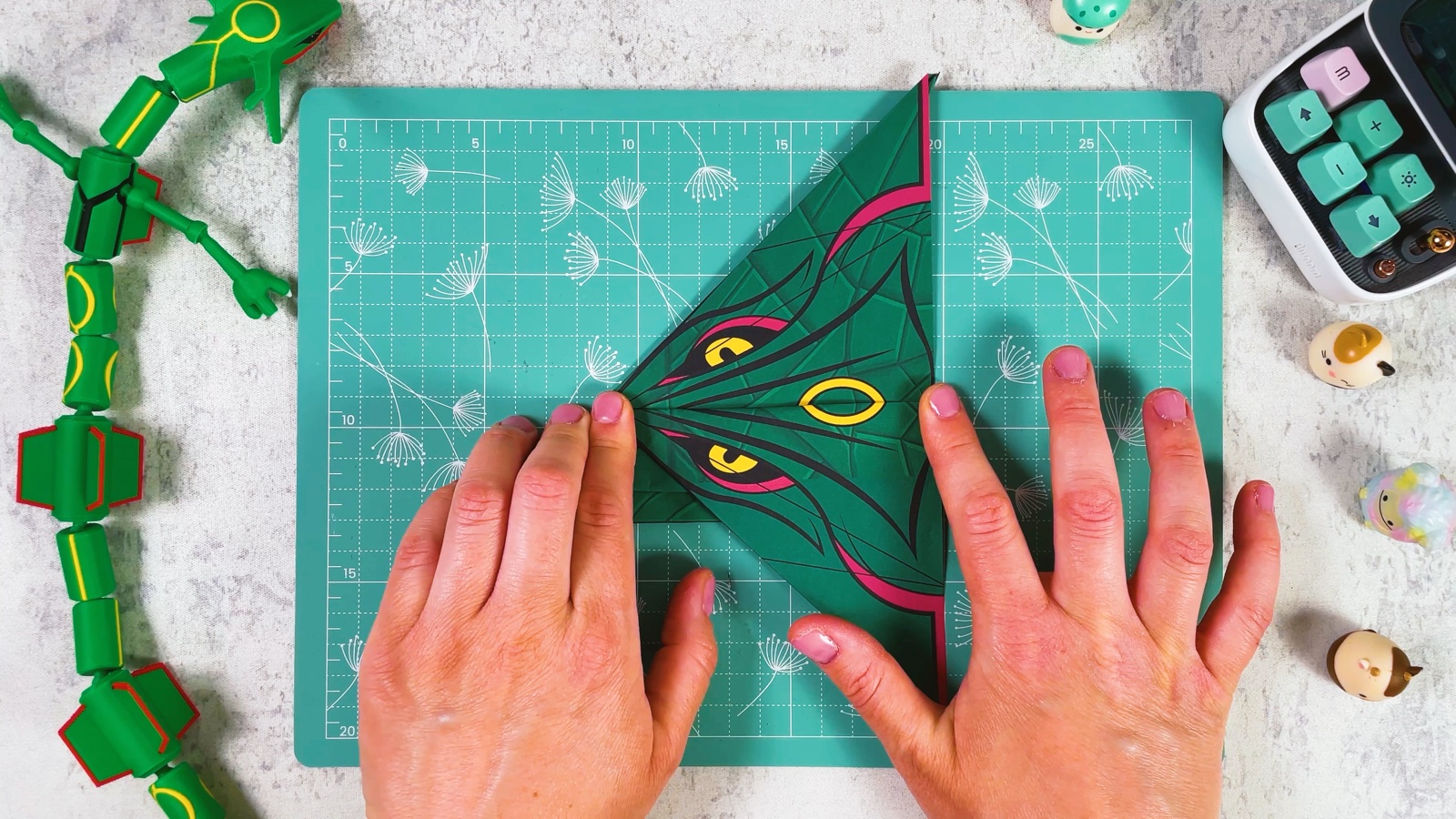 Folding the second wing, with Rayquaza’s eye and a yellow ring showing on the wing