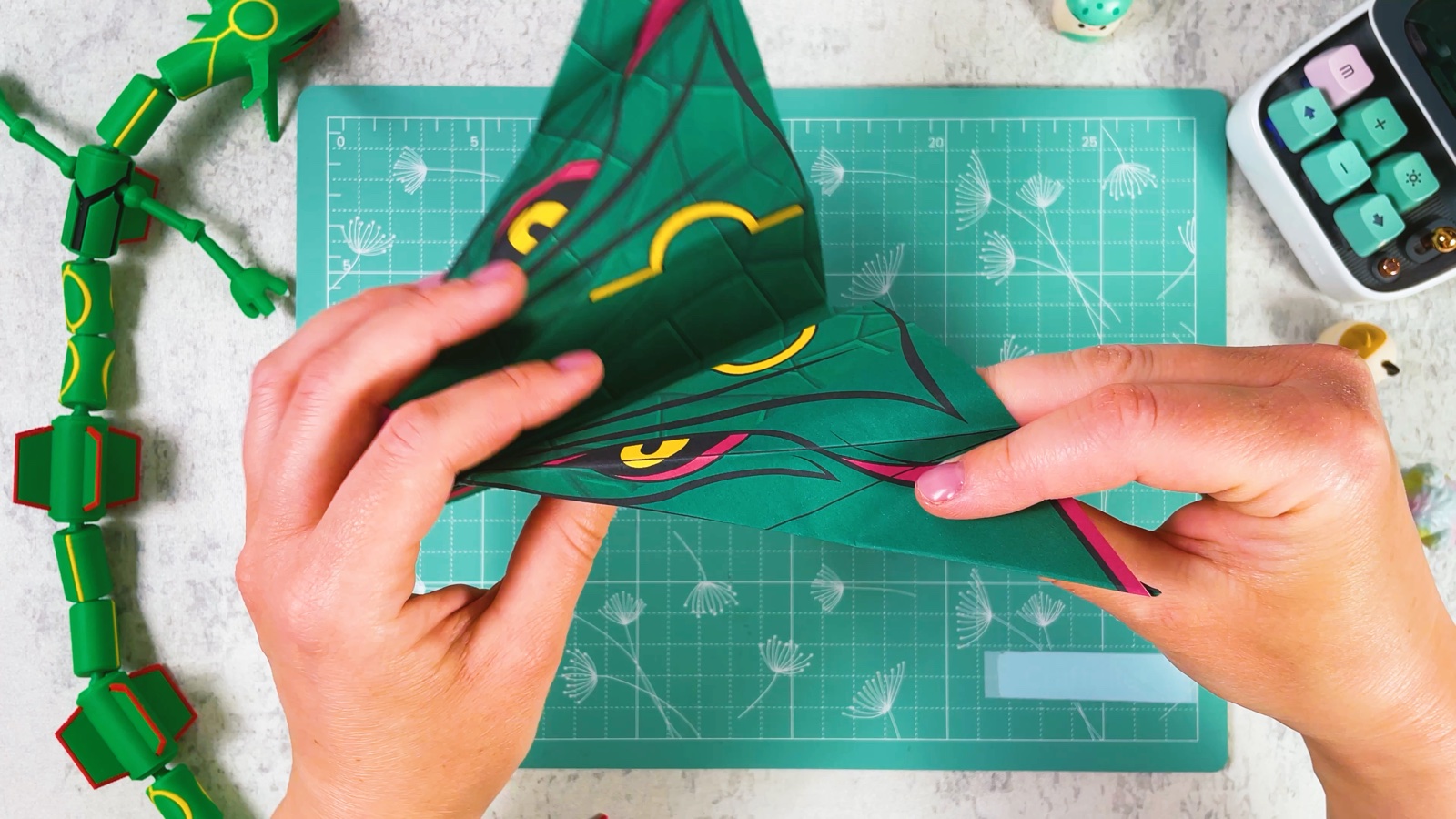 Shaping a wing between the fingers, with the red eye and yellow ring visible on the top
