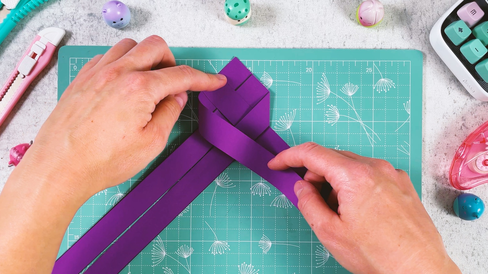 La bande violette extérieure repliée par-dessus le haut de la tresse