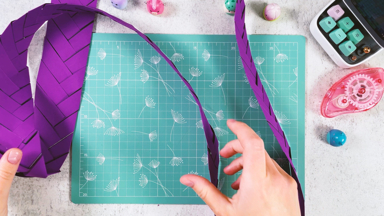 La longue tresse en papier violet qui serpente sur le tapis de découpe