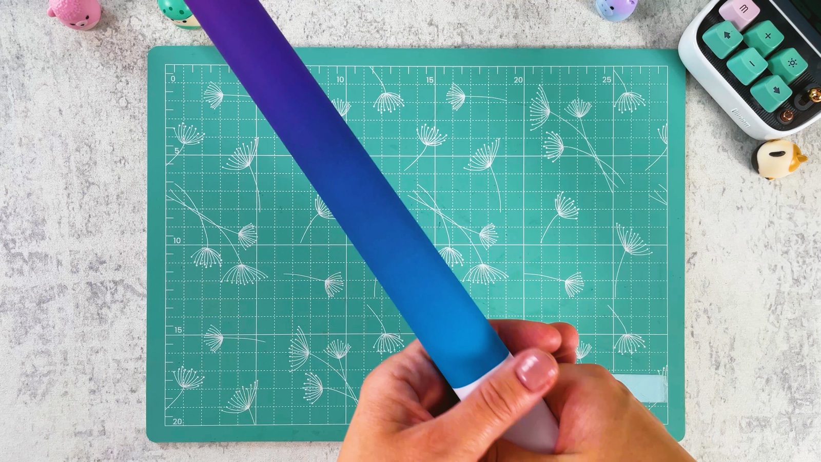 Le long tube de papier terminé, tenu en main, violet et bleu à un bout
