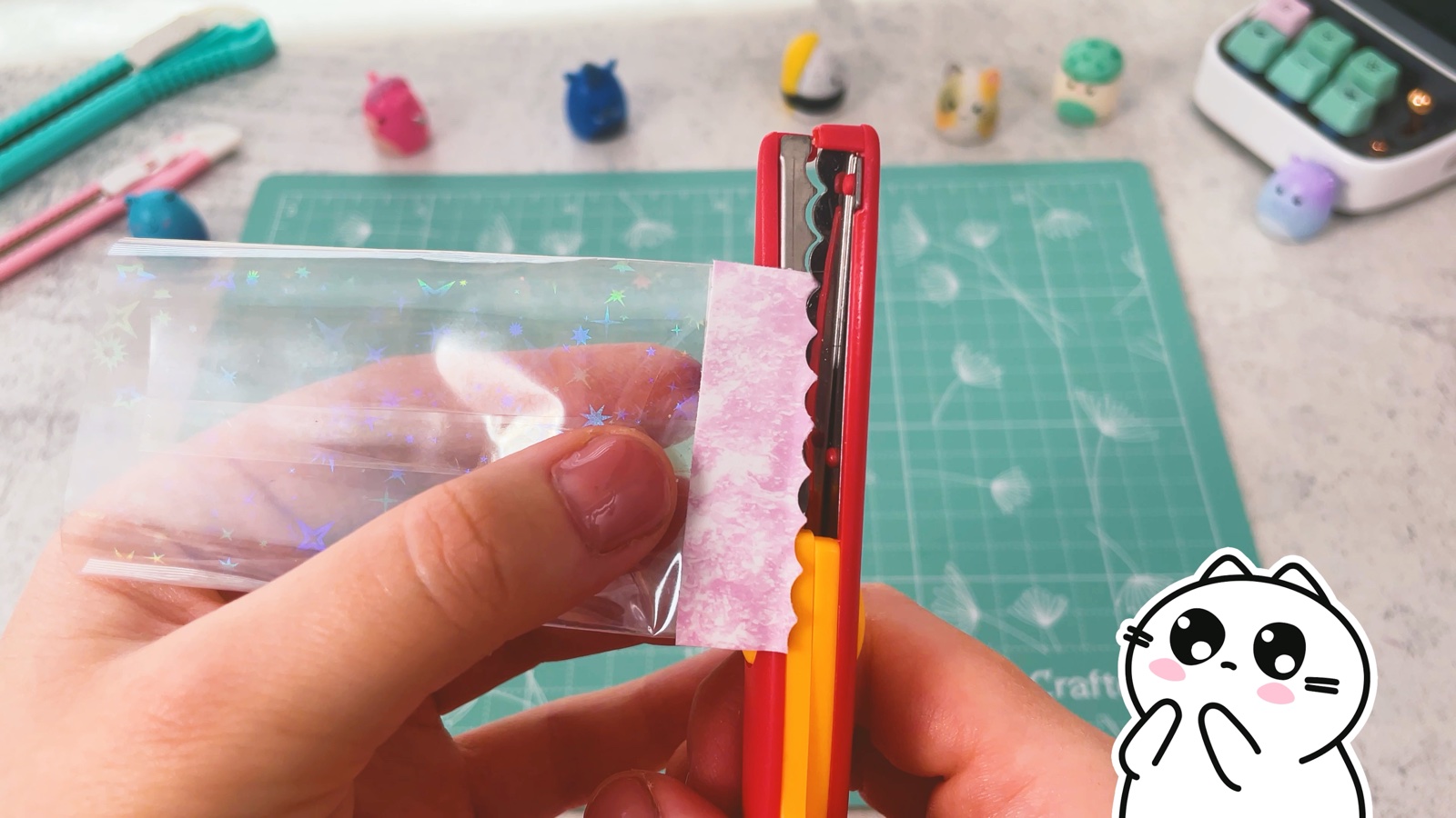 Mit einer roten Zackenschere wird ein welliger Rand in das rosa Papierende geschnitten