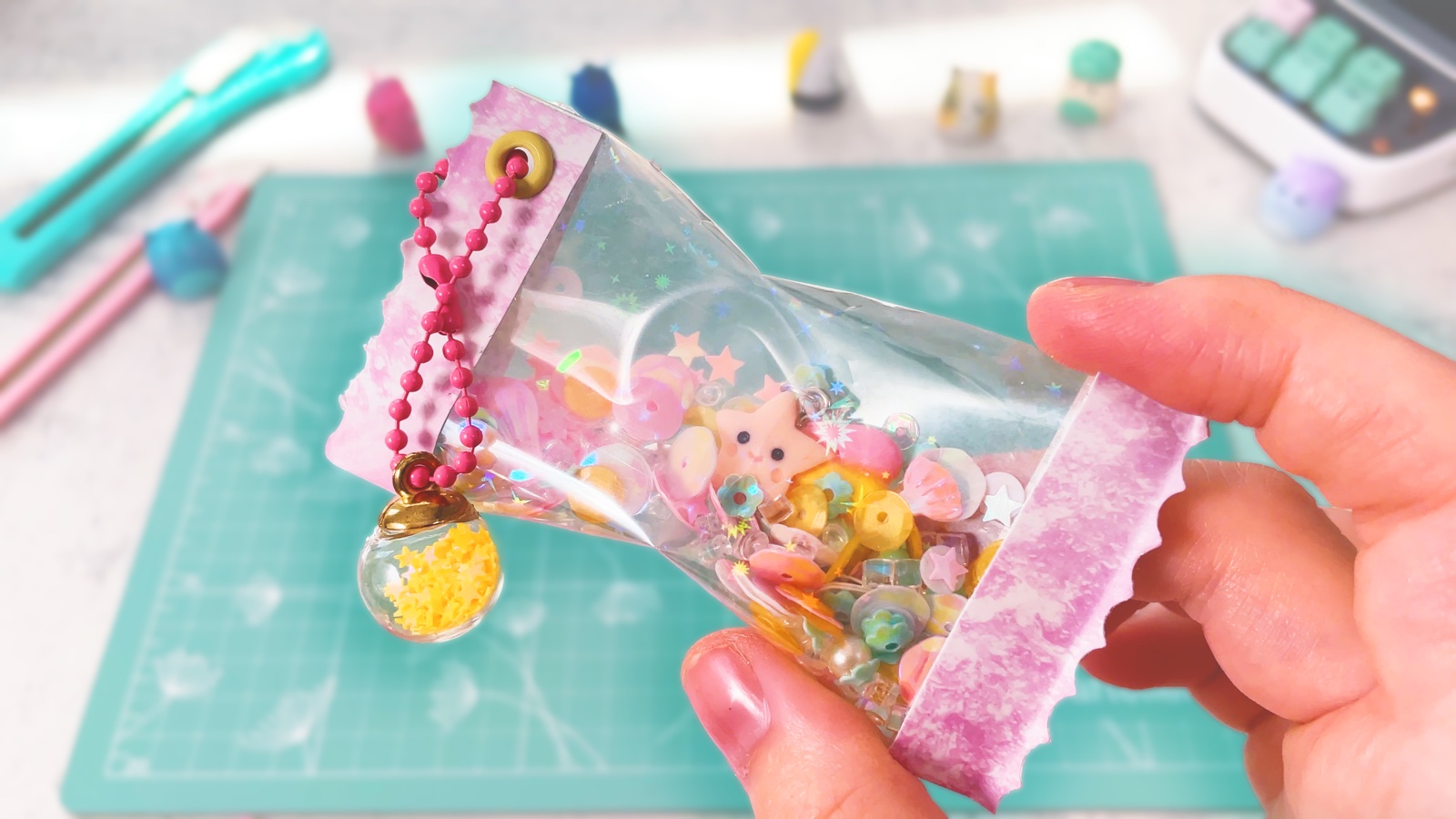 Finished sparkly shaker keychain full of pastel sequins, with pink paper ends and a pink ball chain