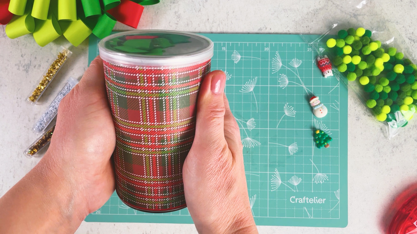 The can fully covered in plaid paper, held in both hands