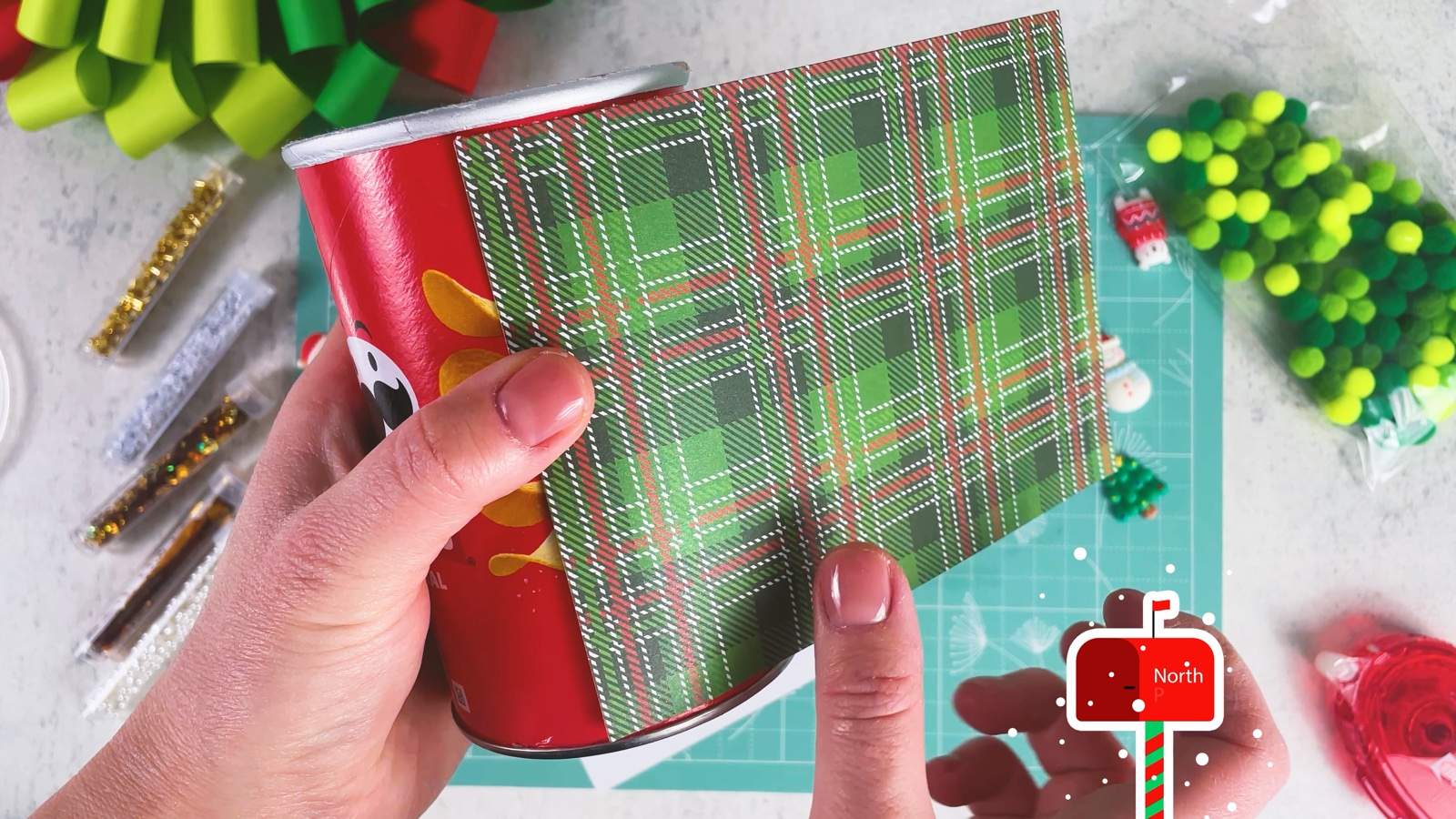 Wrapping green plaid paper around the red Pringles can