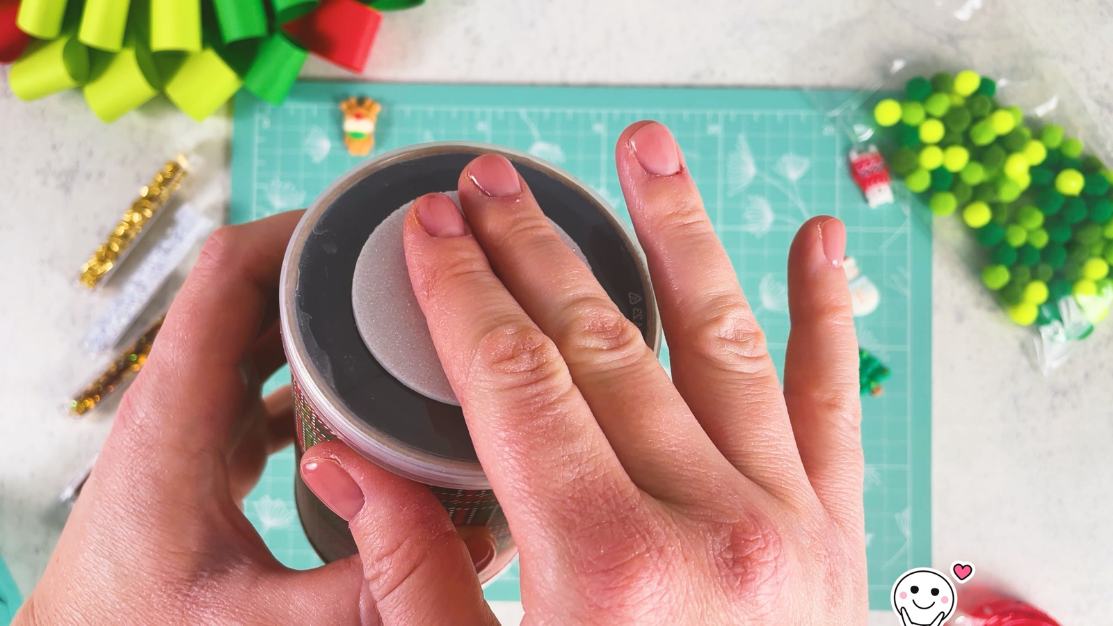 Pressing the silver glitter circle into the lid of the can