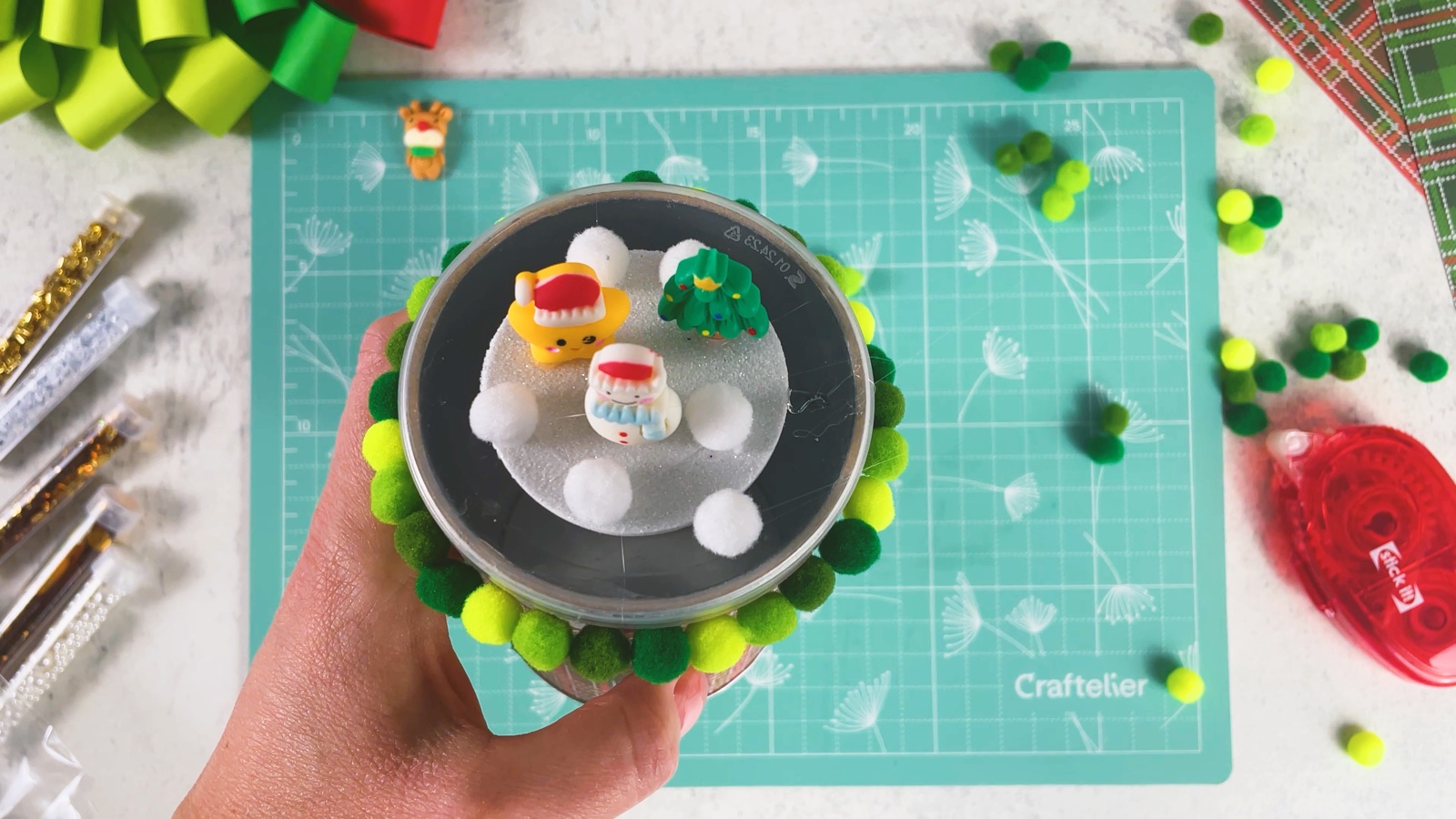 White pom-pom snowballs glued around the figurines on the lid