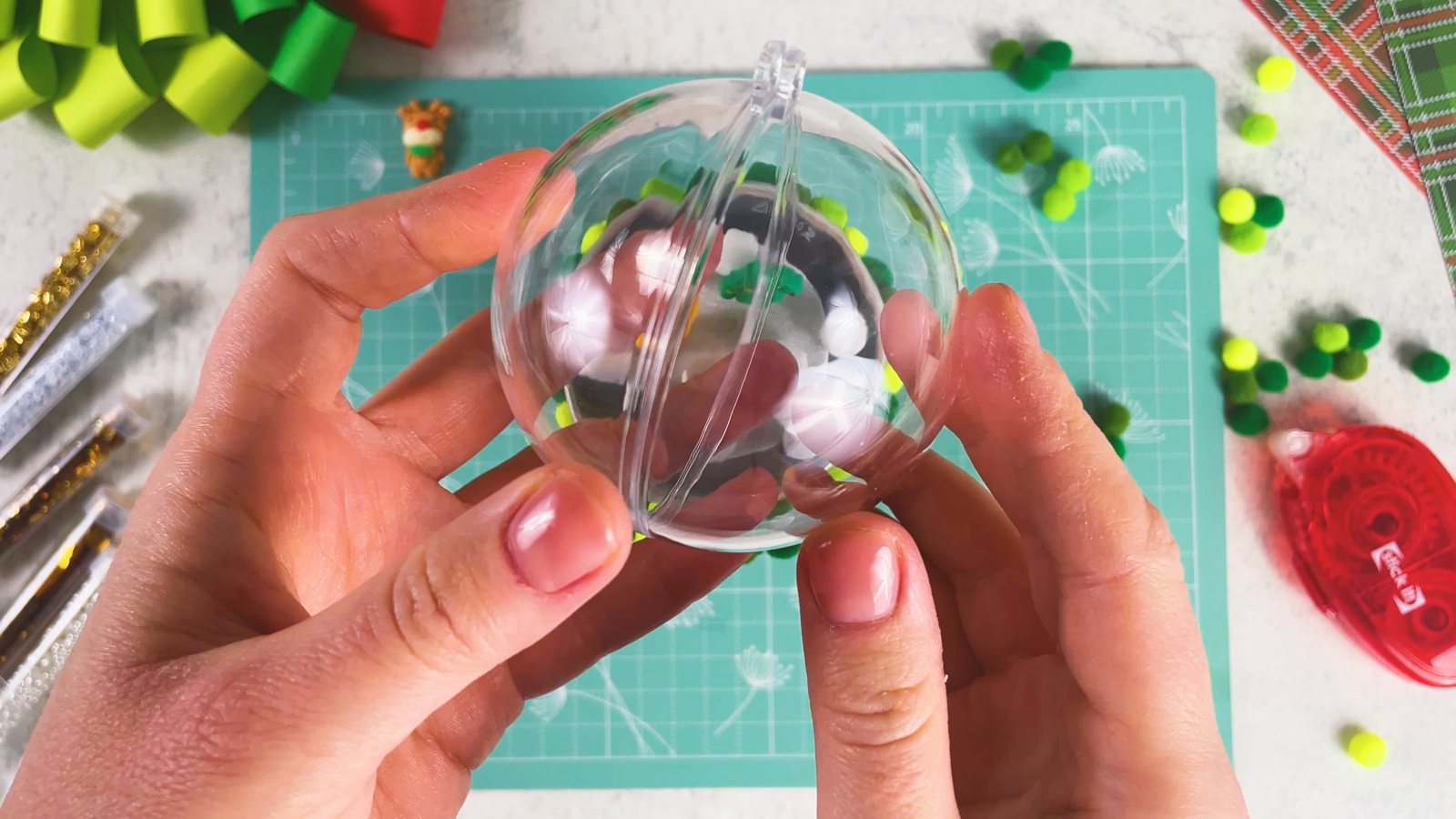Pulling a clear plastic bauble apart into two halves