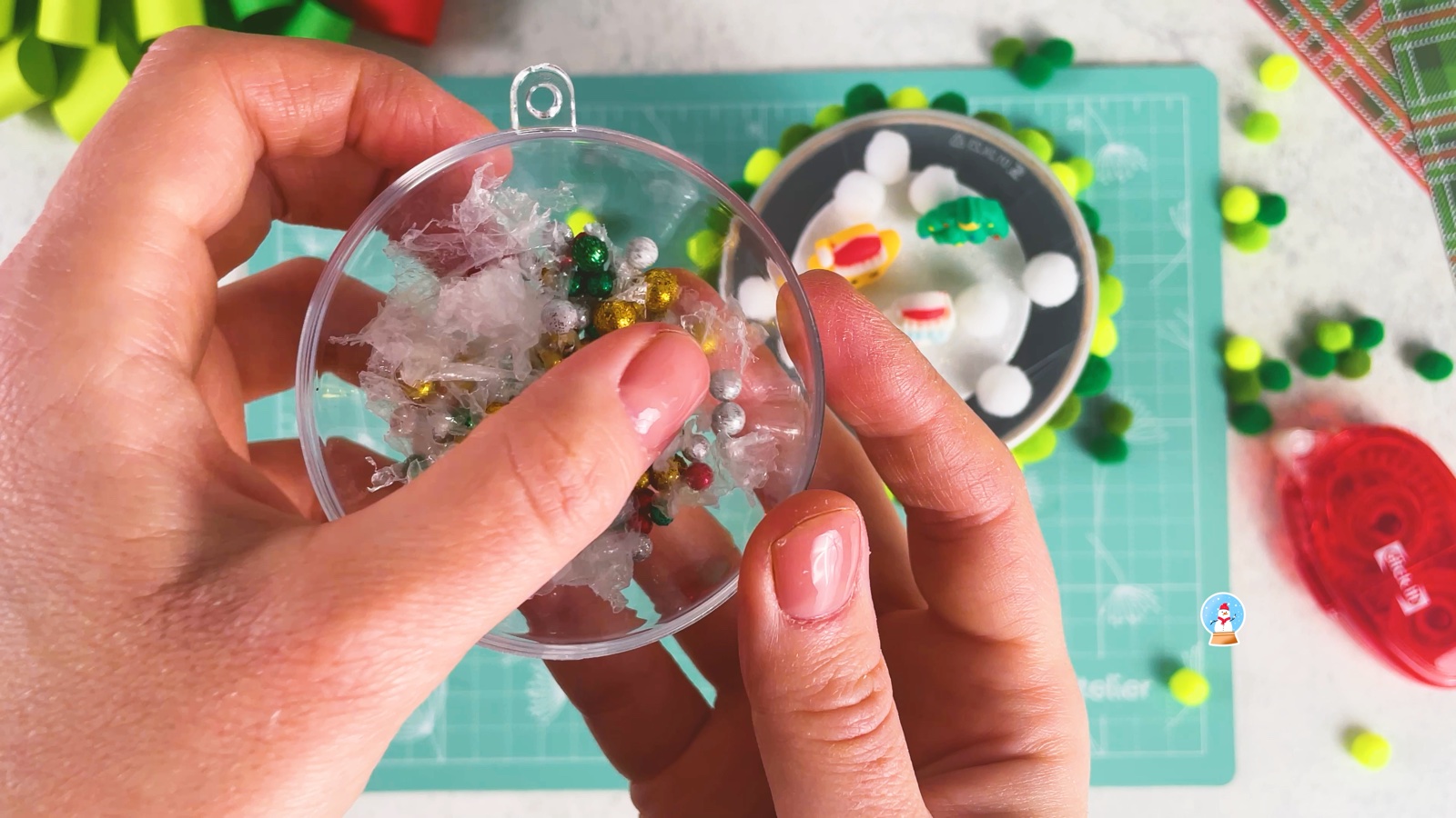 Tucking fluffy fake snow into the bauble half over the beads
