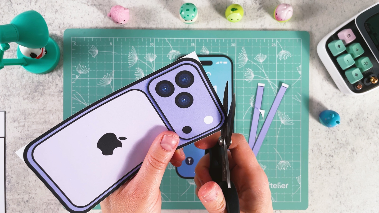 Cutting out the purple back of the phone with scissors around its rounded corner