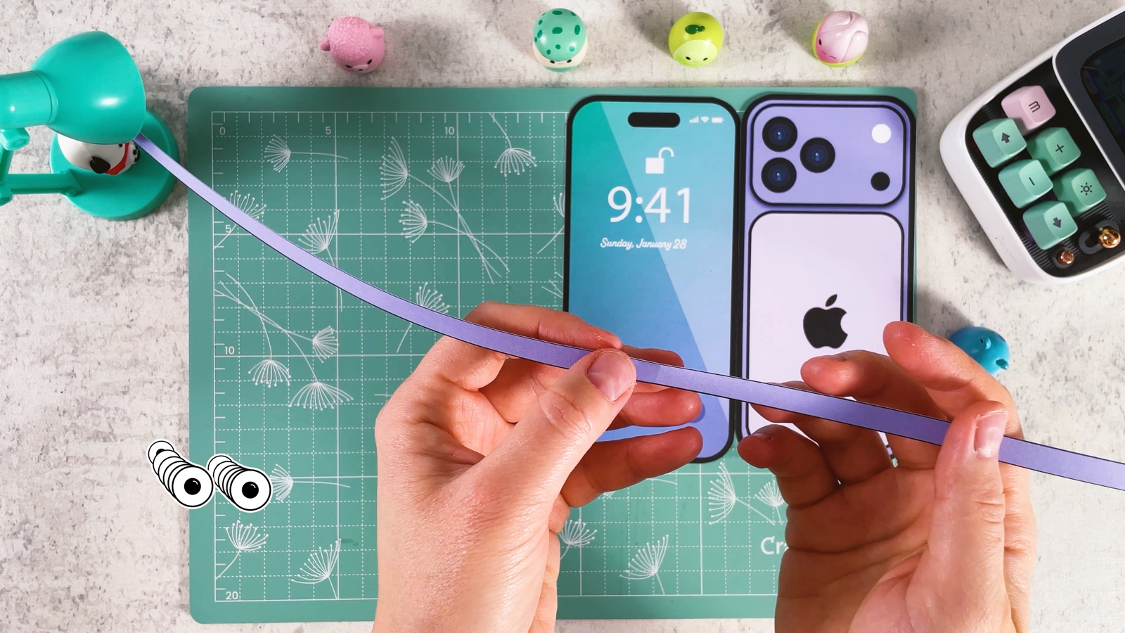 Holding one long purple strip made from the side strips taped together