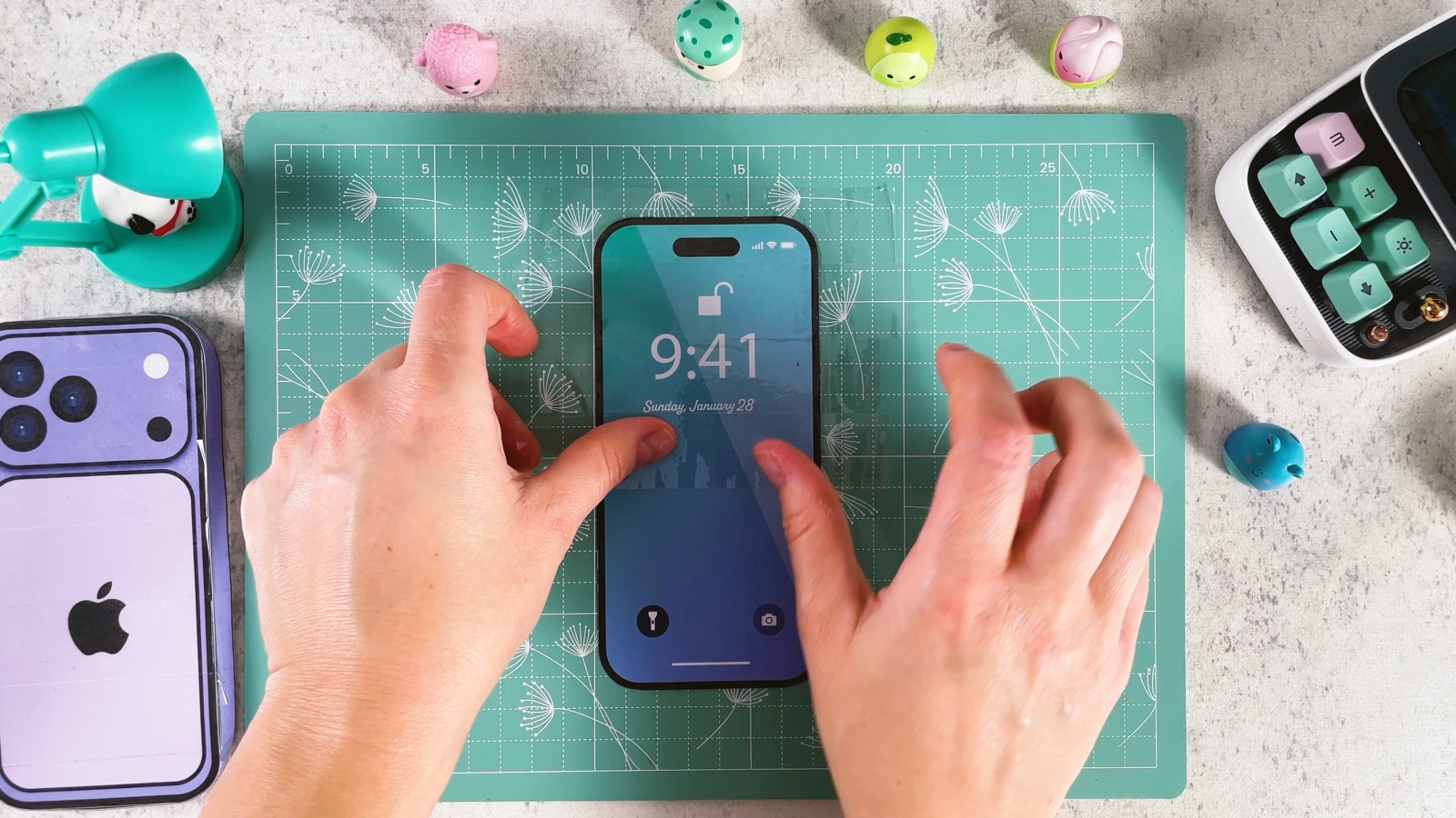 Smoothing clear packing tape over the blue lock screen