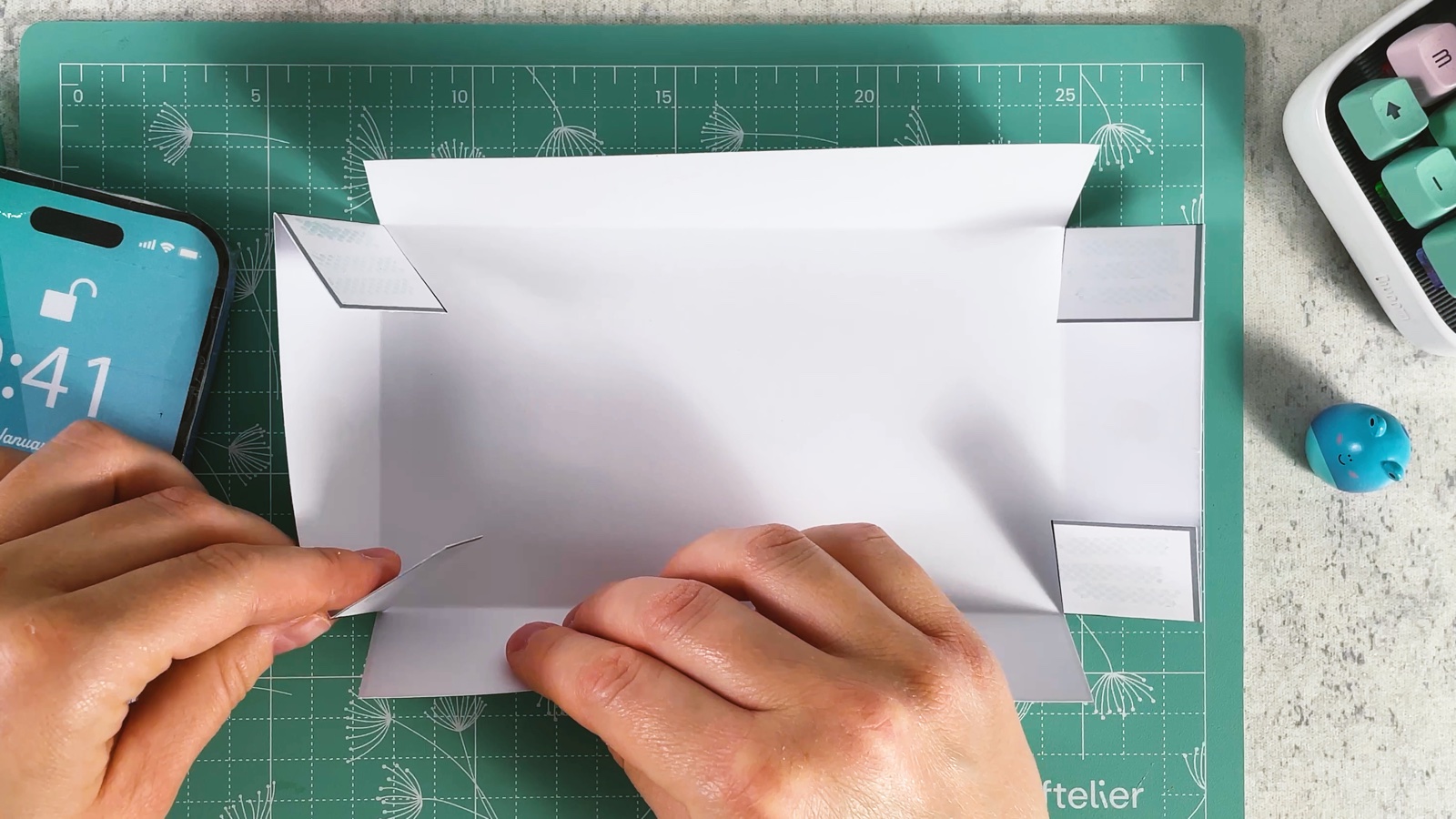 The lid turned over, plain side up, with its folded sides and the grey corner flaps sticking out