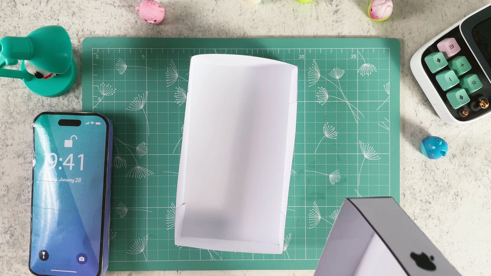 The finished plain white box bottom, an open tray, next to the box lid