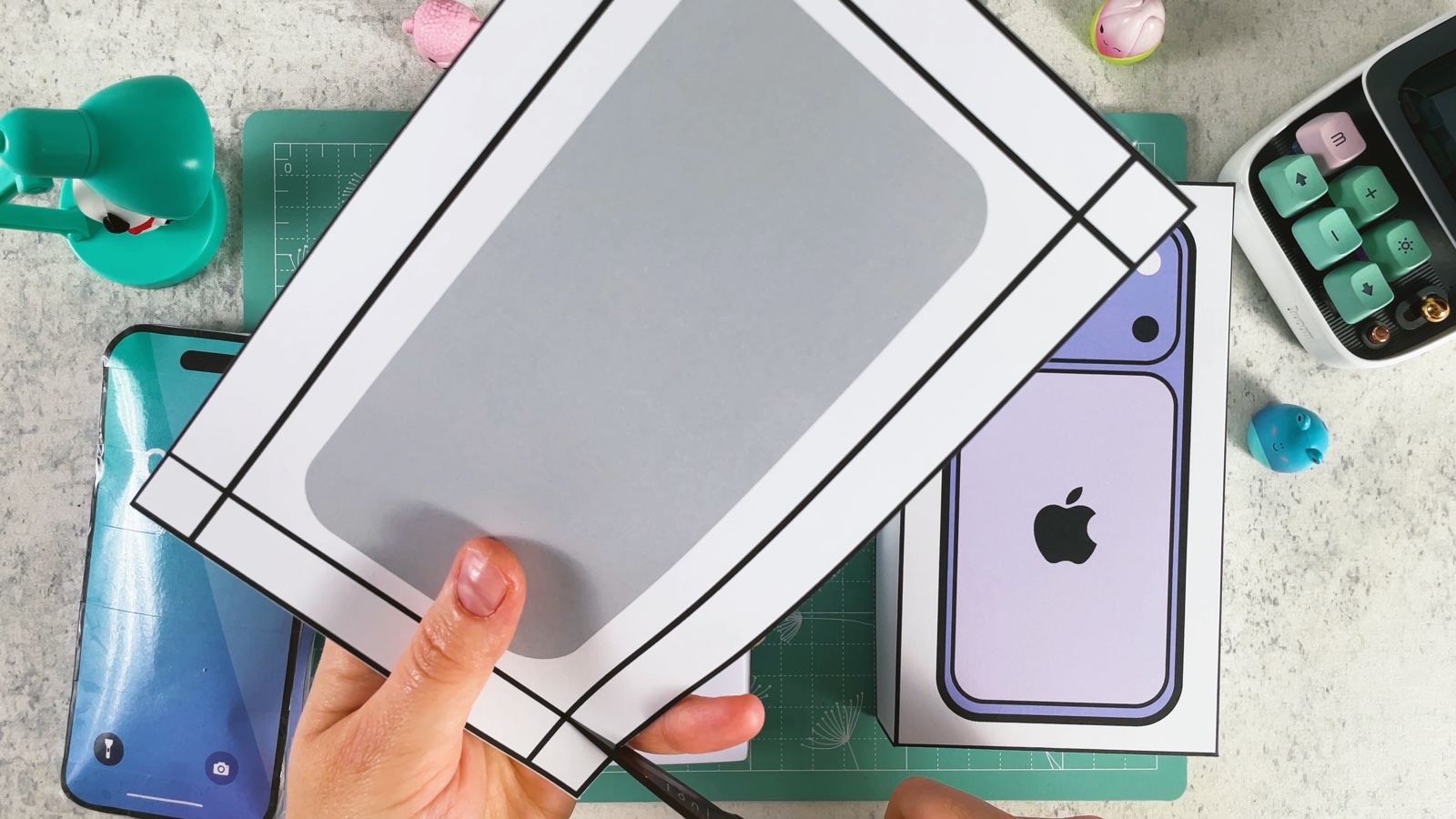 Cutting out the insert page with the grey phone shape