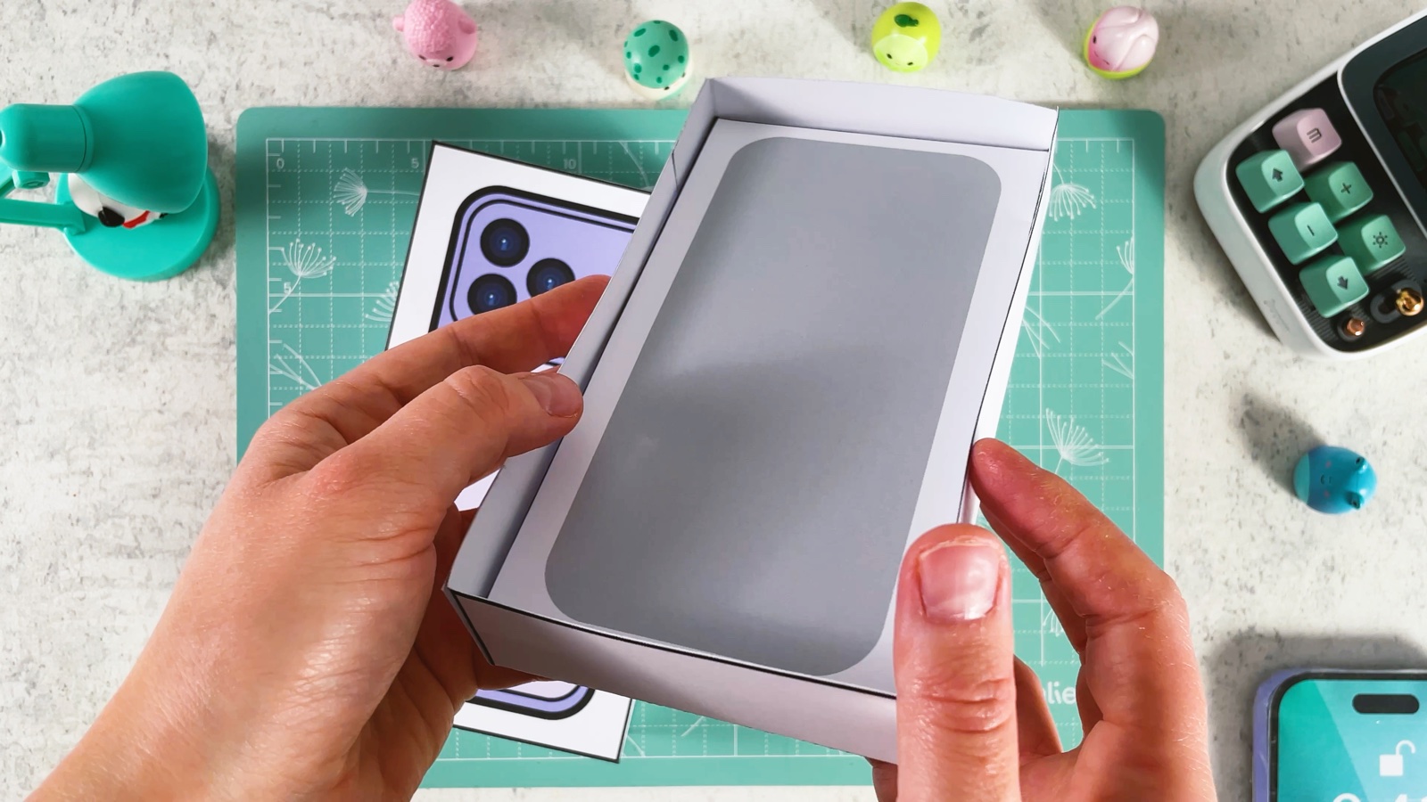 Placing the insert with the grey phone shape into the white box bottom