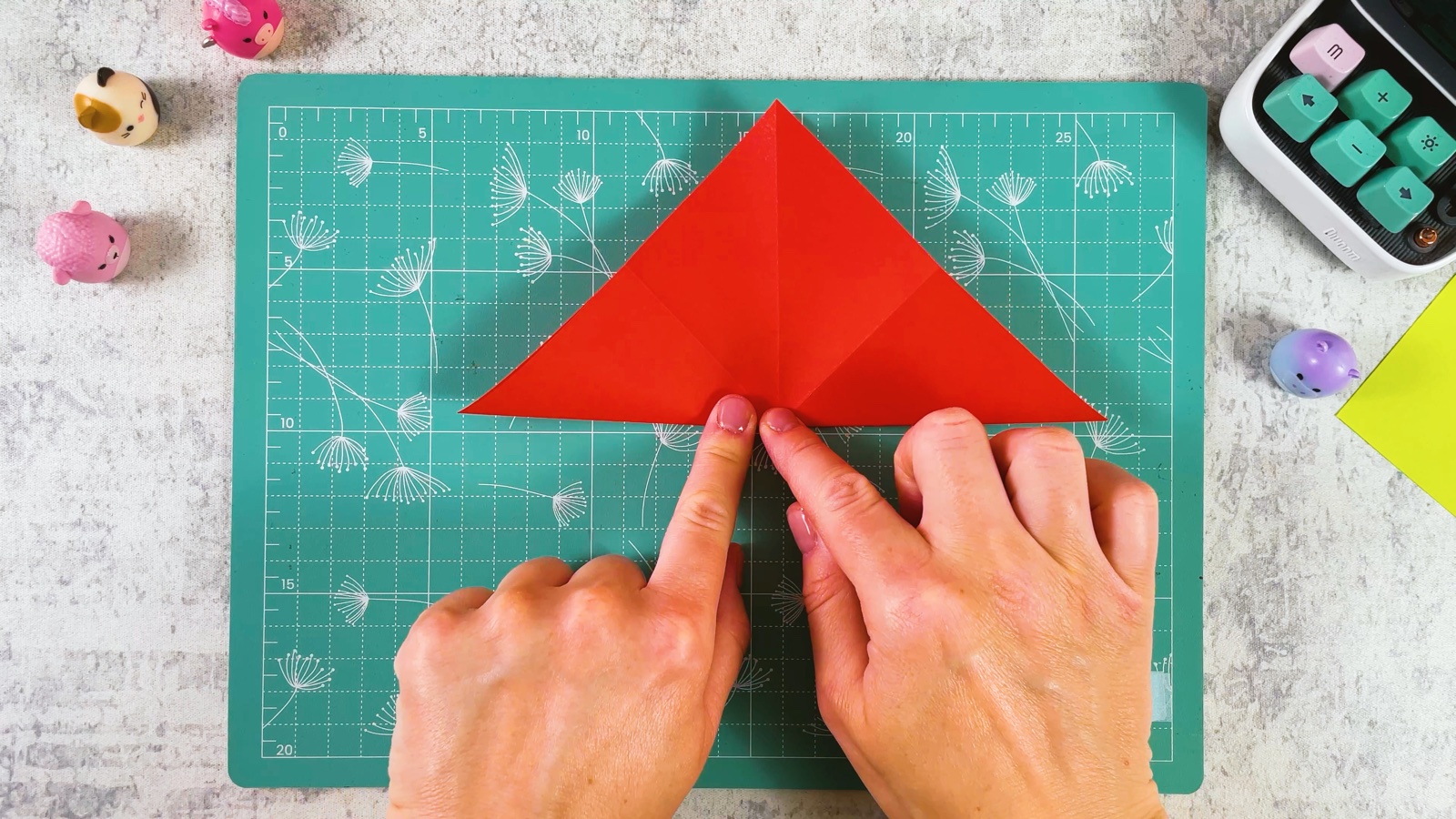 The red square collapsed into a layered triangle on the cutting mat