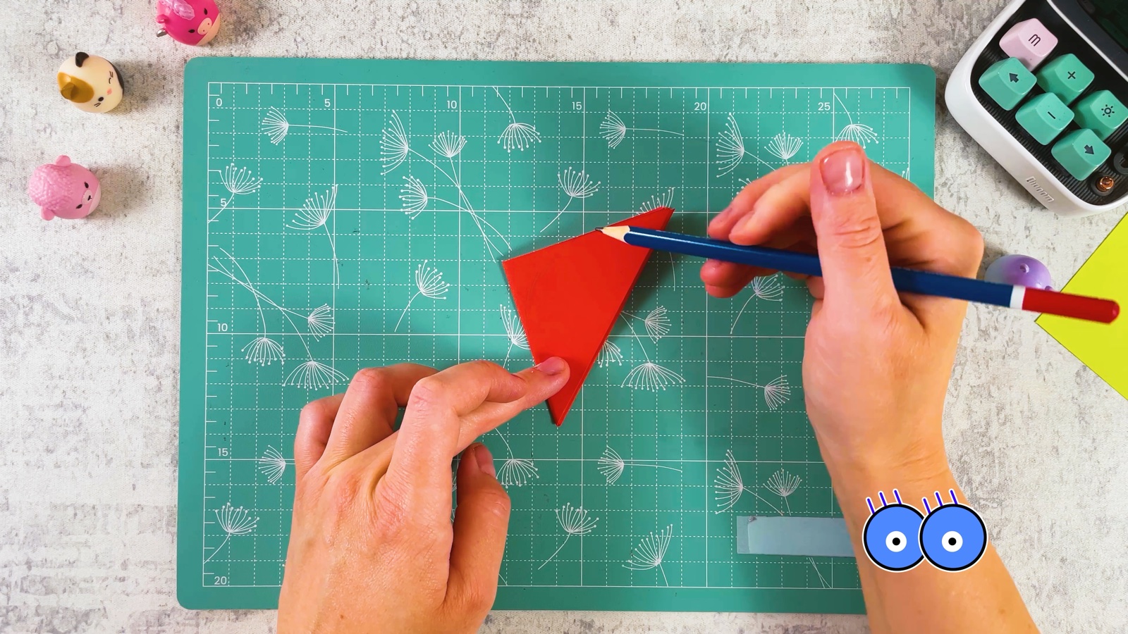 Drawing a petal shape on the folded red wedge with a pencil