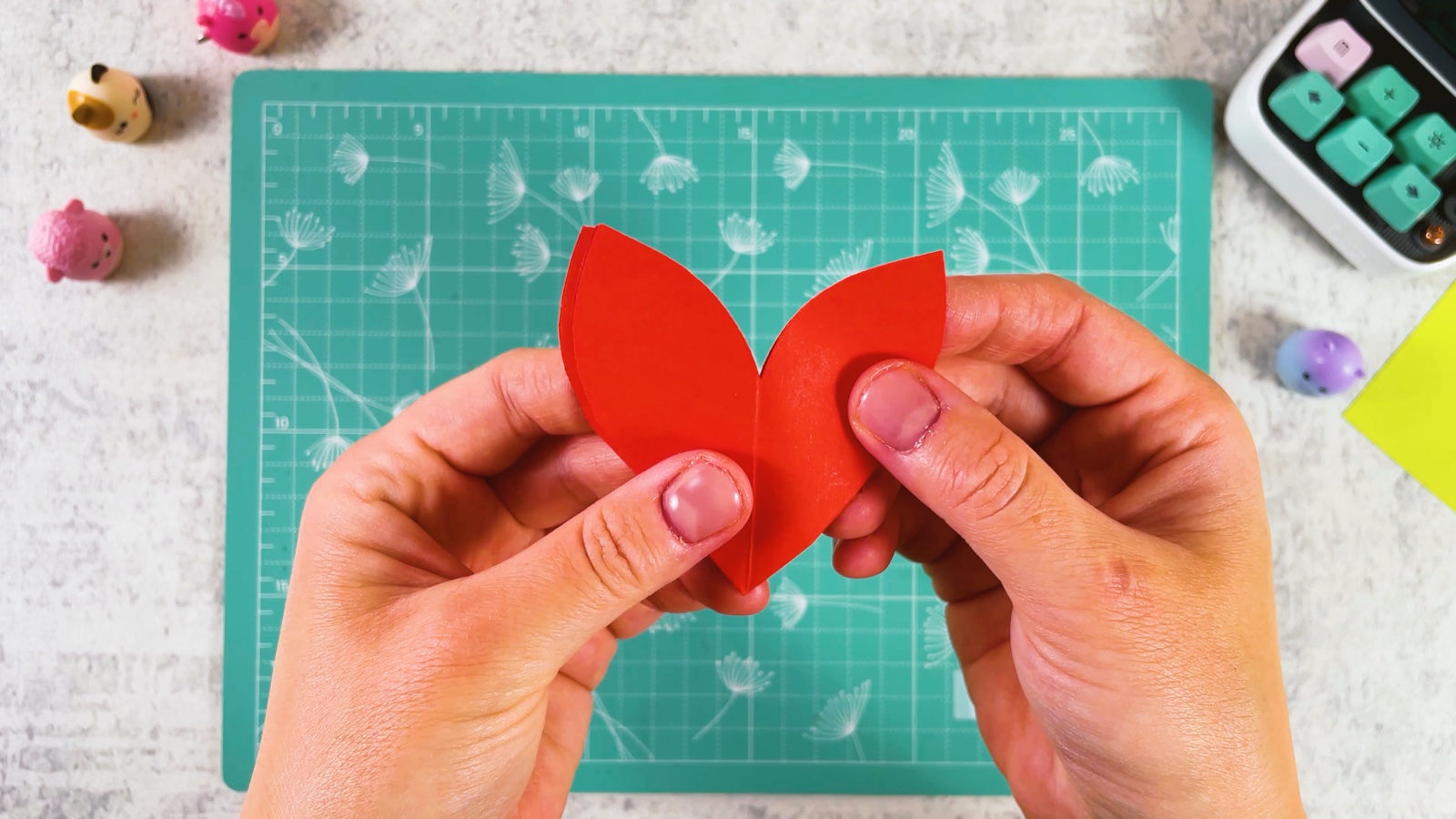 Unfolding the cut red paper into a flower shape