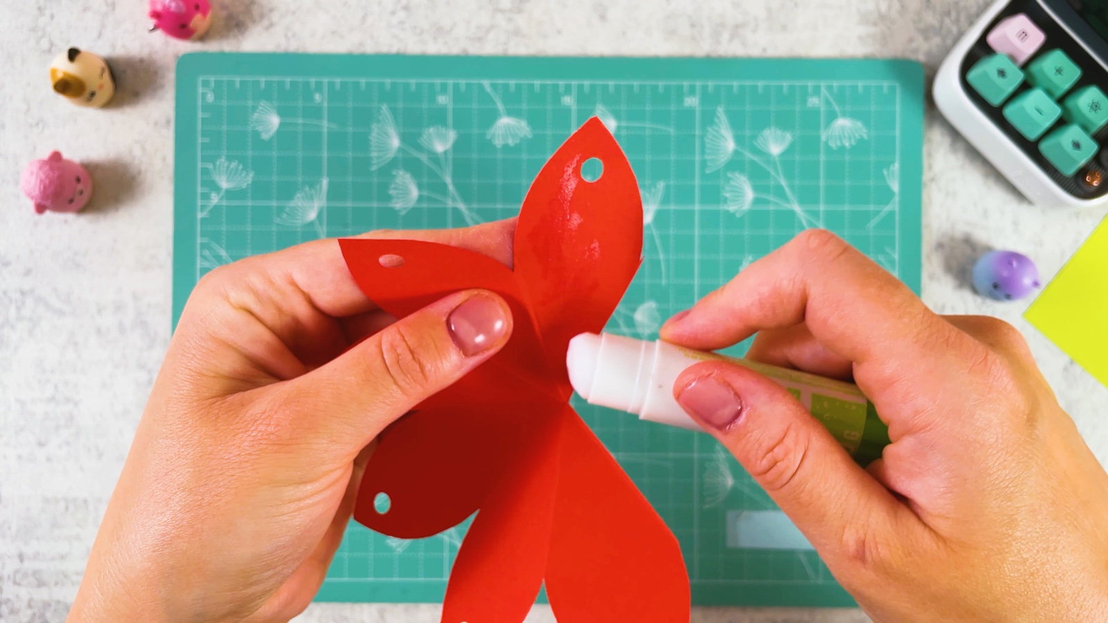 Putting glue stick on one red petal to overlap it with the next one