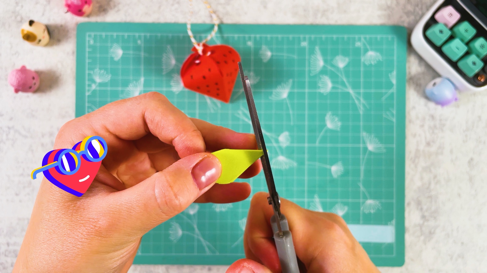 Cutting a pointy leaf shape from the folded green paper
