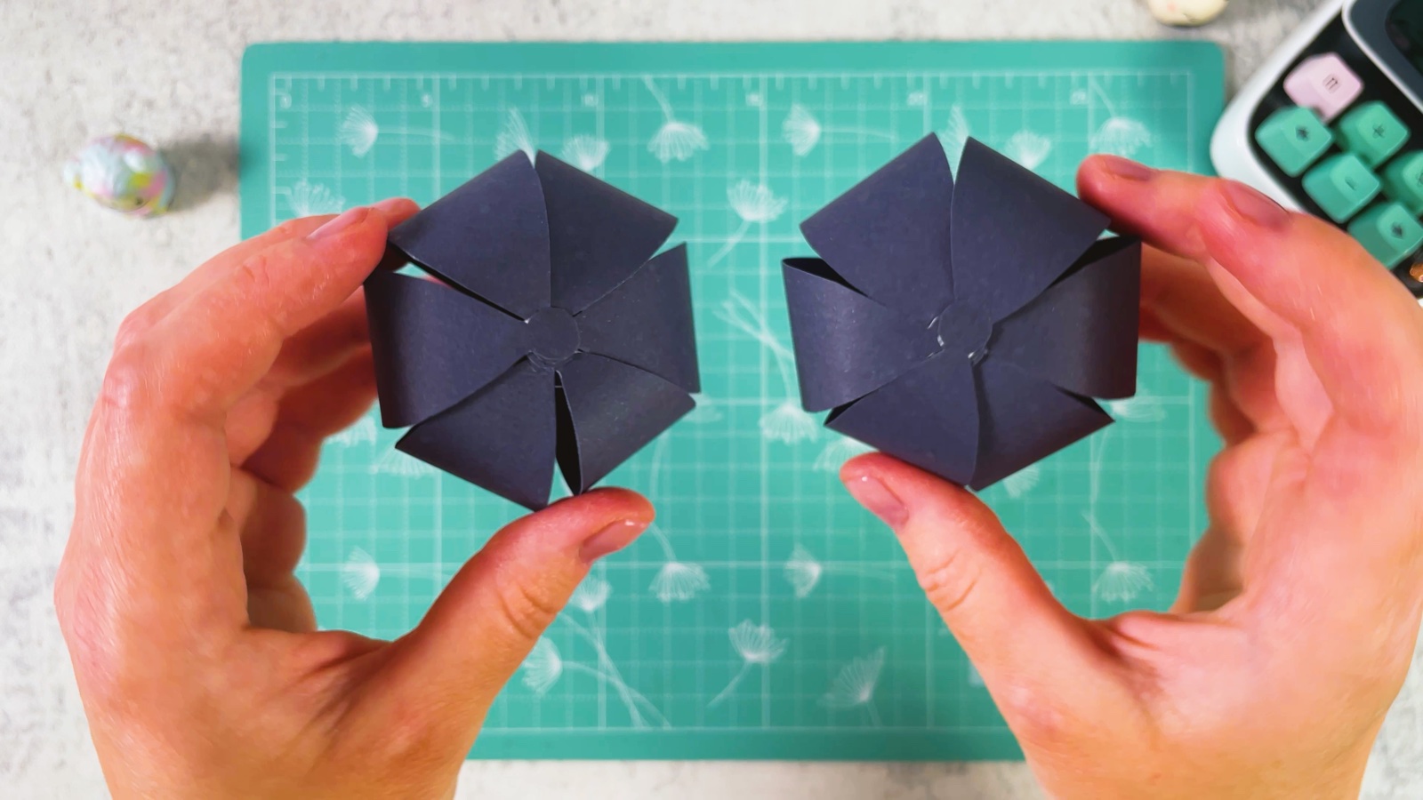 Holding two finished round paper buns side by side