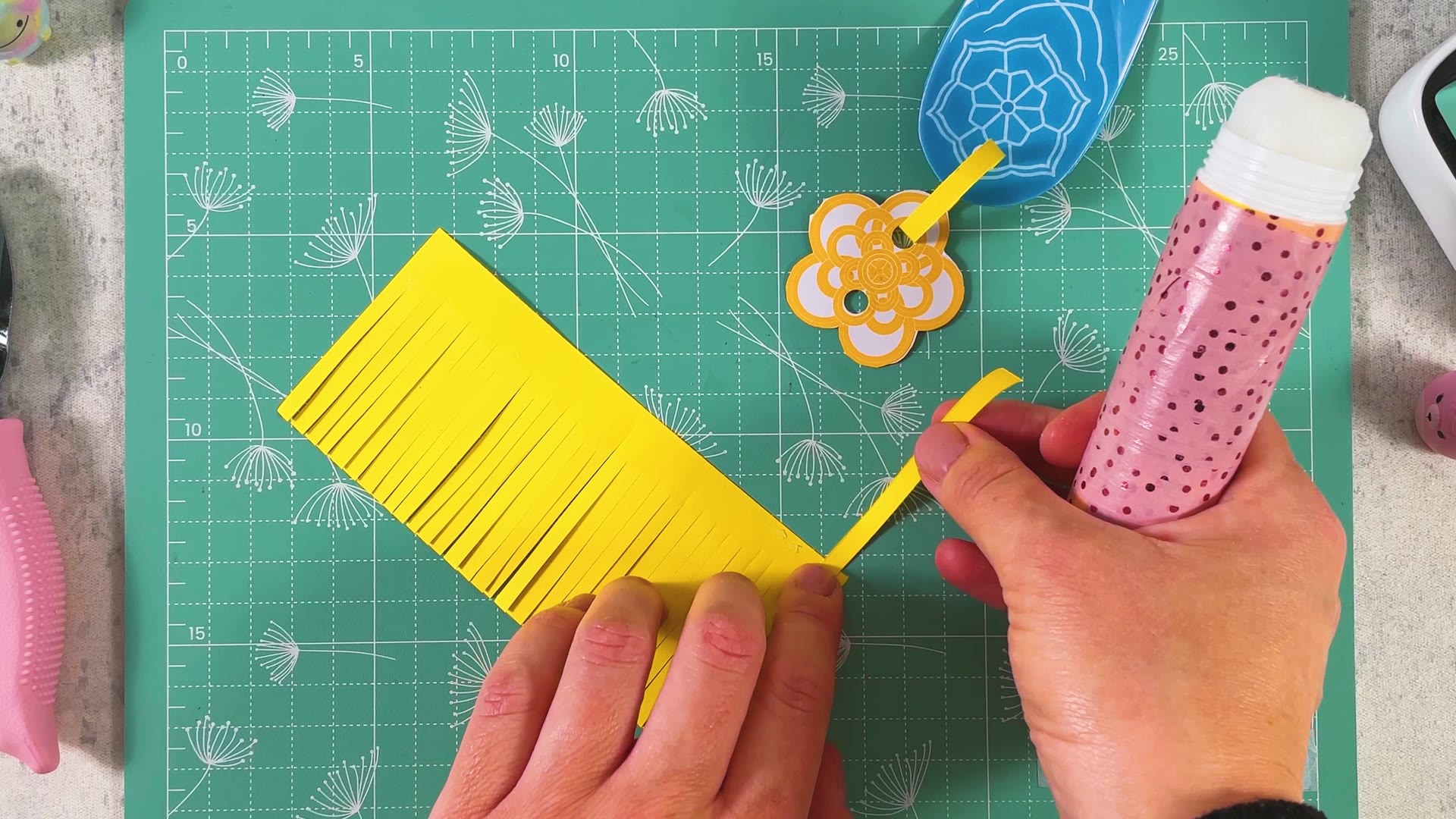 Gluing the yellow cord onto the uncut edge of the fringe